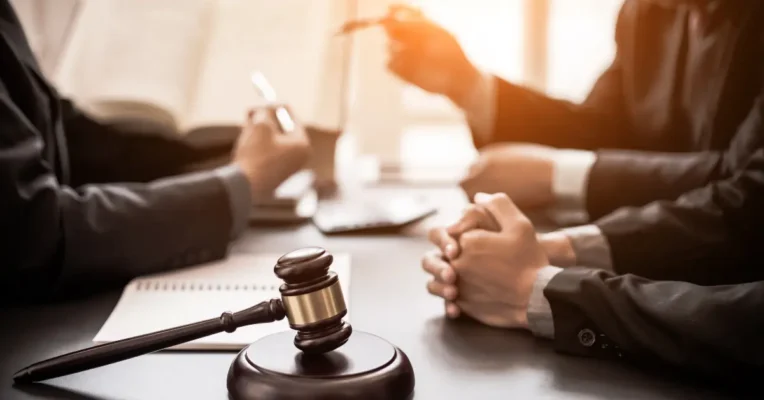 Wills and estate lawyers in a meeting discussing legal documents with a gavel prominently displayed