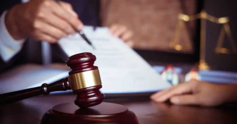 Living trust attorney explaining legal paperwork with a gavel and scales of justice in the foreground