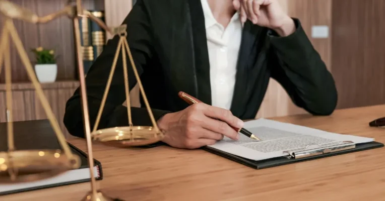 estate lawyer reviewing a legal document with scales of justice on the desk