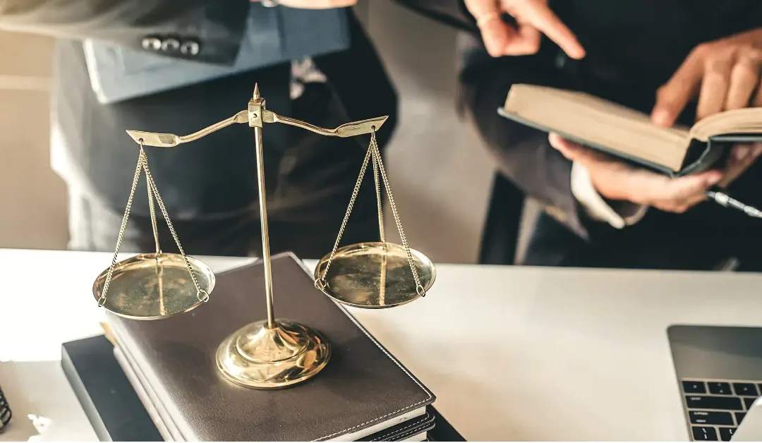 Scales of justice on a desk as two trust lawyers review documents together