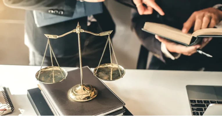 Scales of justice on a desk as two trust lawyers review documents together